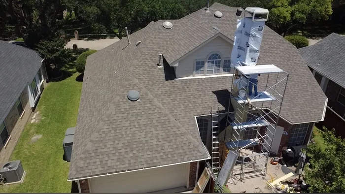 Aerial view of scaffolding set up against a wrapped chimney chase mid-project